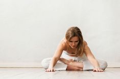 a woman sitting on the floor with her legs crossed