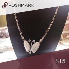 a necklace with two white birds on it and the words poshmark $ 15