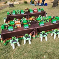 a table topped with lots of green and brown decorations on top of a grass covered field