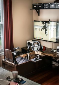 a living room filled with furniture and a flat screen tv mounted above a wooden desk