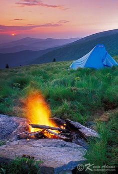 a campfire with a tent in the background