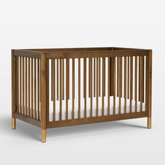 a wooden crib with white sheets on the bottom, and wood trim around the sides