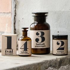 three bottles with numbers on them sit next to each other in front of a brick wall