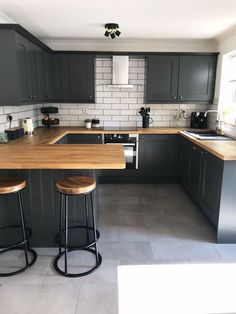 an image of a kitchen setting with bar stools and counter top in the middle