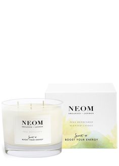 neom candle in front of a box on a white background with the words neom written