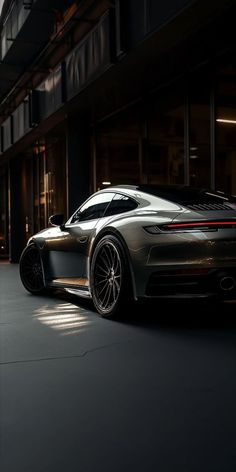 a grey sports car parked in front of a building