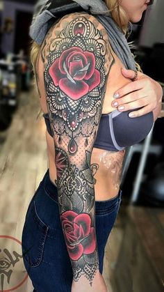 a woman with a rose tattoo on her arm and chest is posing for the camera