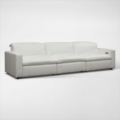 a white leather couch sitting on top of a white floor