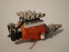 an orange and silver engine on a white surface with no one around it or someone else