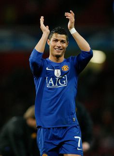 a soccer player is holding his hands up in the air and smiling at the camera