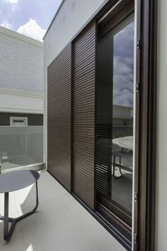 an outdoor patio with table and sliding glass doors on the side of the building,