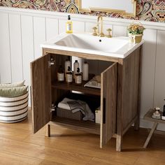 a bathroom sink sitting under a mirror on top of a wooden cabinet next to a wall