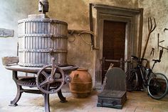 an old fashioned kitchen with pots and pans on the stove, next to a bicycle