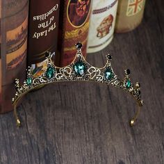 a tiara sitting on top of a wooden table next to books