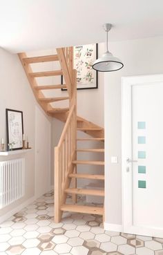 there is a wooden stair case in the room with white walls and tile flooring