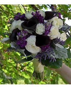 a woman holding a bouquet of white and purple flowers