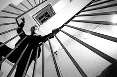 black and white photograph of two people standing on the top of a spiral stair case