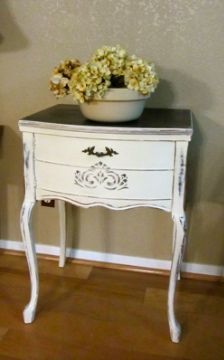 a small white table with flowers on top