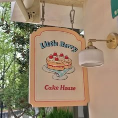 a sign hanging from the side of a building that says little bary cake house