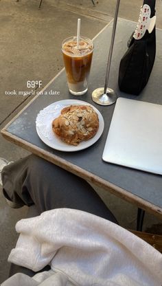 a person sitting at a table with a plate of food in front of them and a laptop on the table