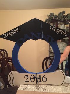 a graduation cap on top of a sign that says congrats and has the year 2016