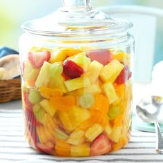 a glass jar filled with sliced fruit on top of a table