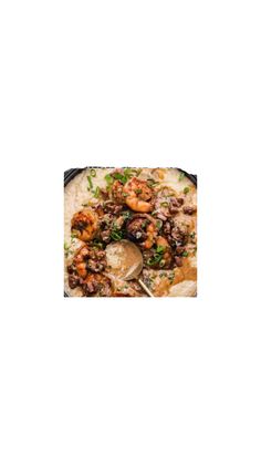 a pan filled with shrimp and mushrooms on top of a table