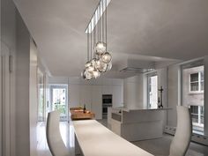 a modern kitchen with an island in the middle and lots of lights hanging from the ceiling