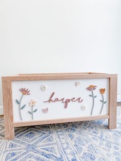 a wooden sign with flowers and the word larger on it