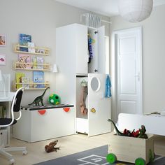 a child's bedroom with white furniture and toys