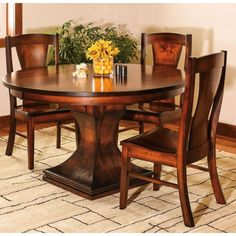 a wooden table with chairs around it and flowers on the table in front of it