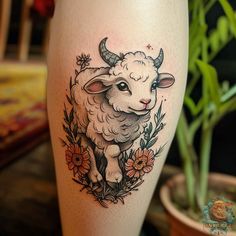 a sheep tattoo on the leg with flowers around it