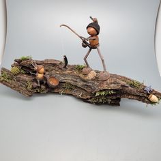 a figurine is standing on top of a piece of wood