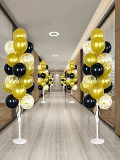 the hallway is decorated with black, white and gold balloons