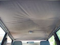 the inside of a van with no roof and two seats in it, covered by a tarp