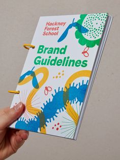 a hand holding up a book with the title'brand guidelines'in front of it