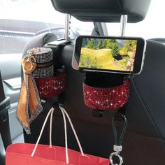 a cell phone in the back seat of a car with some bags hanging from it