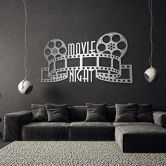 a black and white living room with a couch, coffee table and movie reel on the wall