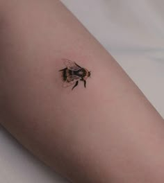 a small bee tattoo on the right arm and leg, it appears to be flying