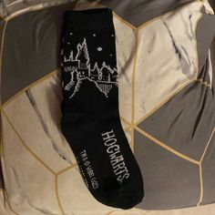 a pair of harry potter socks sitting on top of a bed next to a pillow