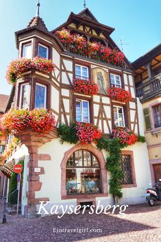 an old building with flowers on the windows