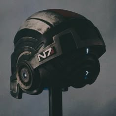 a helmet that is sitting on top of a metal pole in front of a gray background