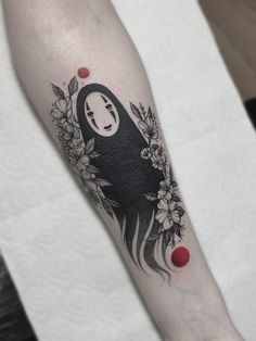 a woman's arm with a black and white tattoo design on the left forearm