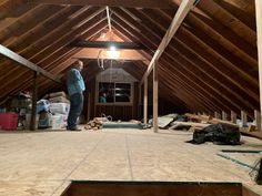 a man standing on top of a wooden floor in a room filled with construction materials