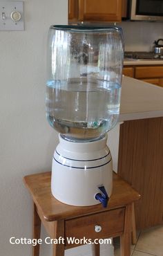 a water dispenser sitting on top of a wooden table in a kitchen