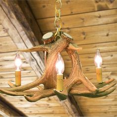 a deer antler chandelier with three candles hanging from it's center