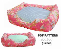 the dog bed is pink with flowers on it and has a blue pillow in front