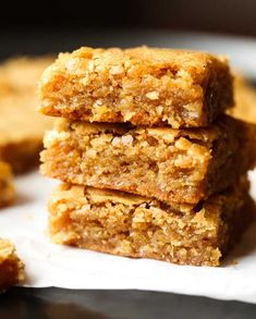 three pieces of granola bars stacked on top of each other in front of some cookies