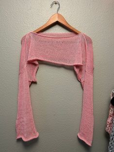 a pink sweater hanging up on a wall