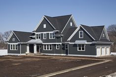 a large gray house sitting on top of a snow covered field